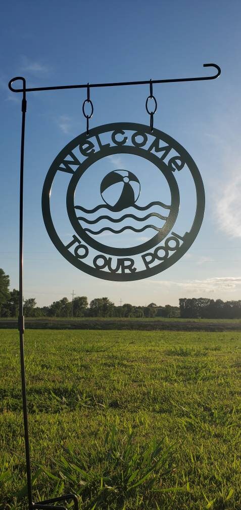 A welcome to our pool garden flag that is made out of metal. 