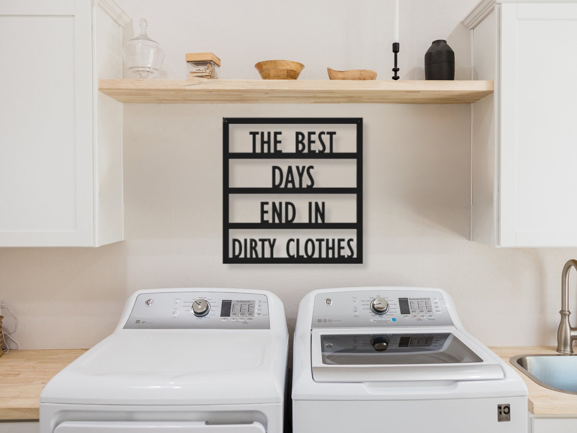 Metal laundry room sign that says The best days end in dirty clothes. It is hanging above the washer and dryer.