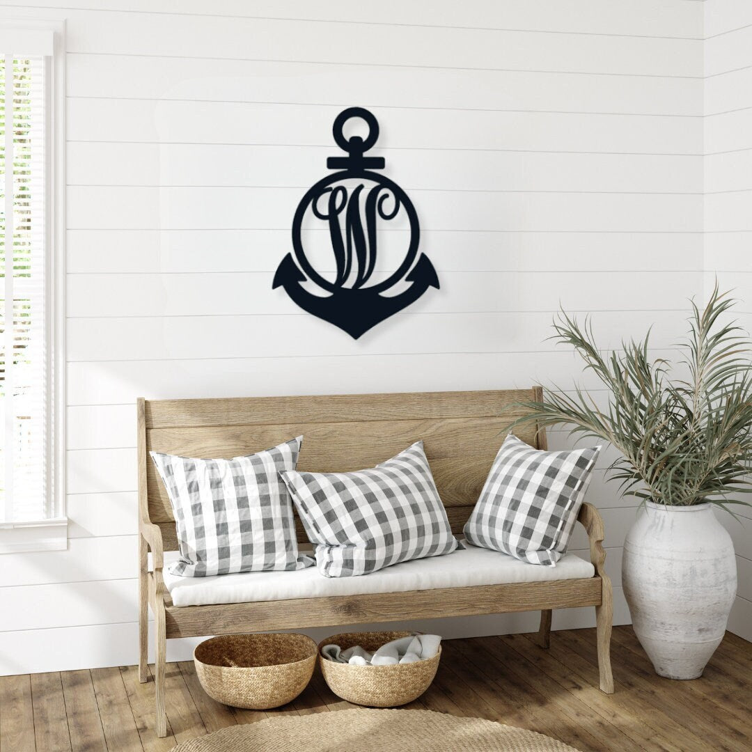 Monogram metal anchor that is hanging above a farmhouse style bench.