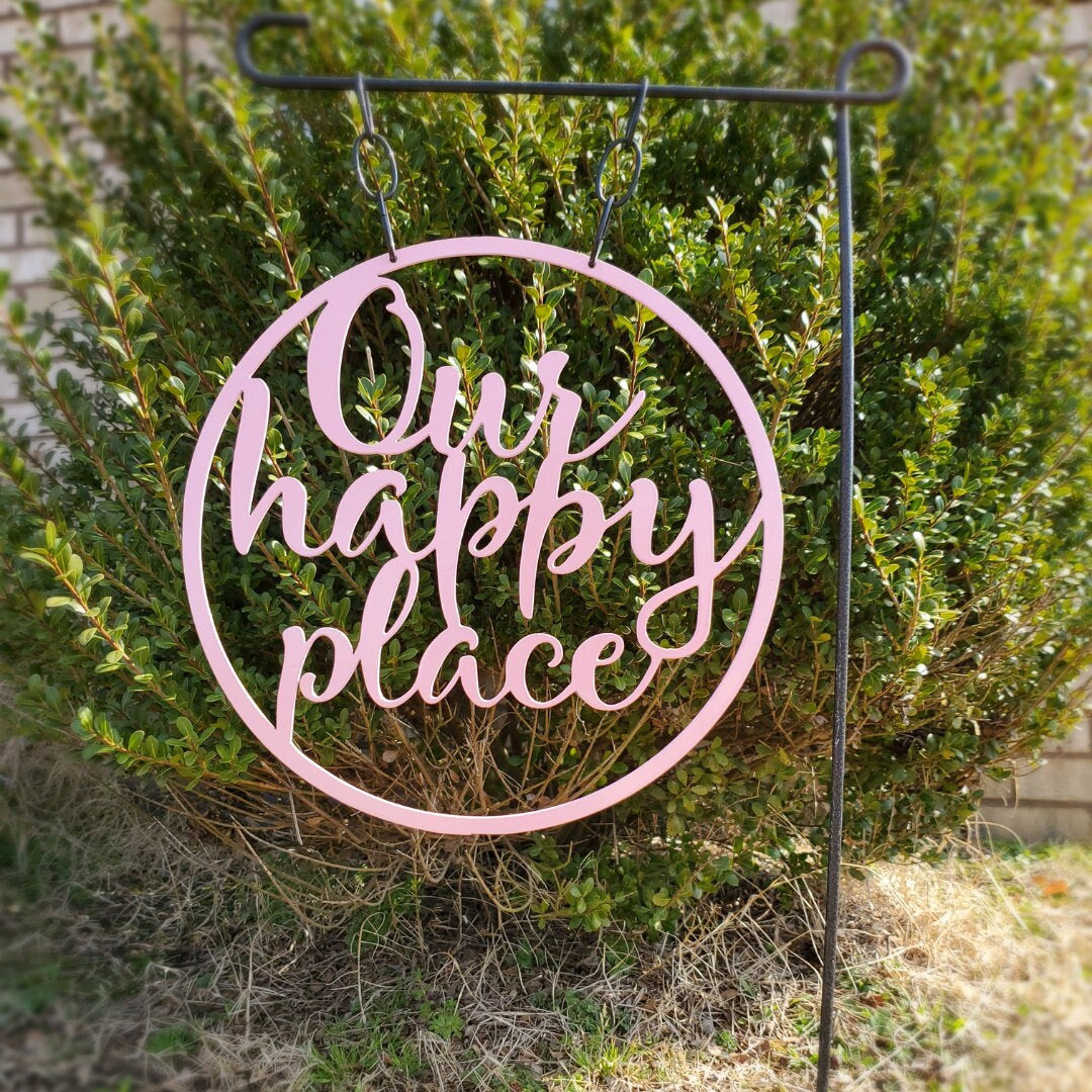 Metal yard art that is a garden flag that says Our happy place.