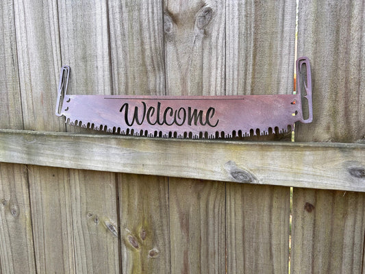 Rustic metal welcome sign that is a saw.